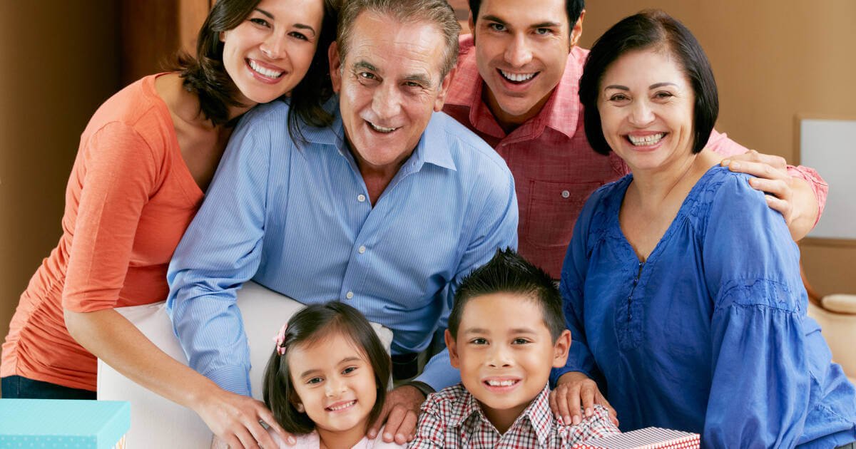 Joyful older dad poses with family, celebrating his birthday with adult children and grandchildren.