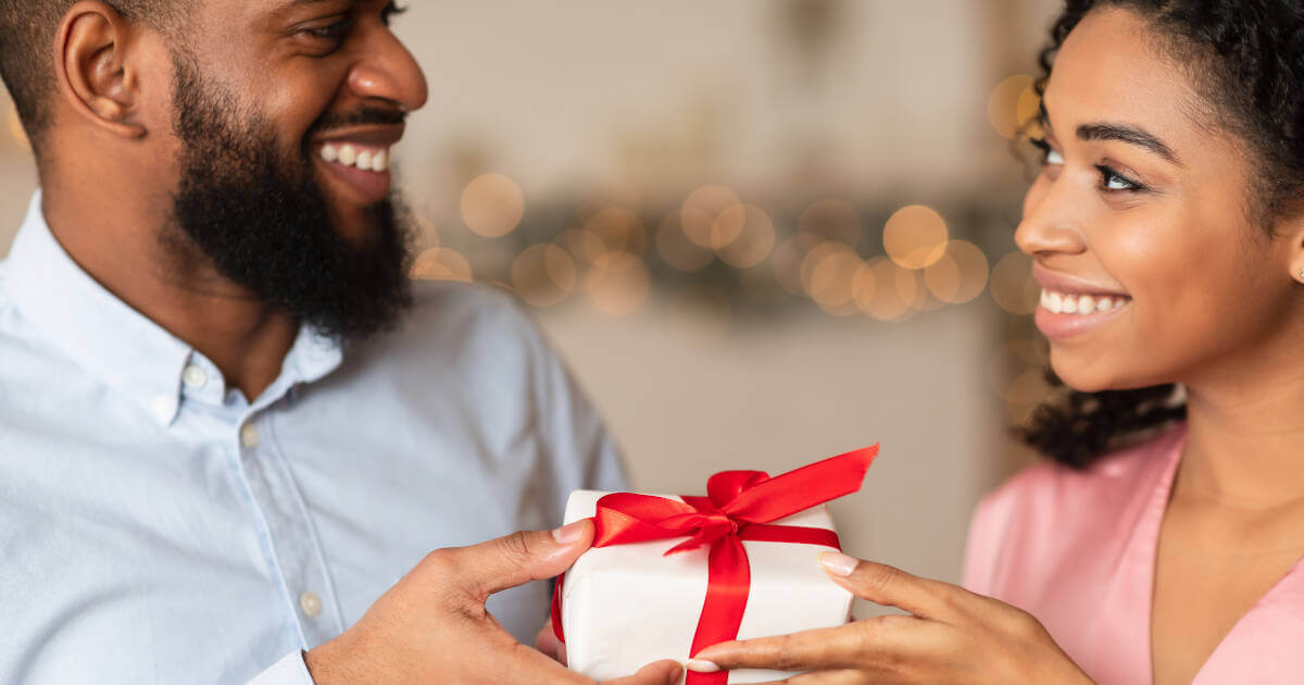 Closeup of happy lovers, a wife exchanging anniversary gifts with her husband on their special day.