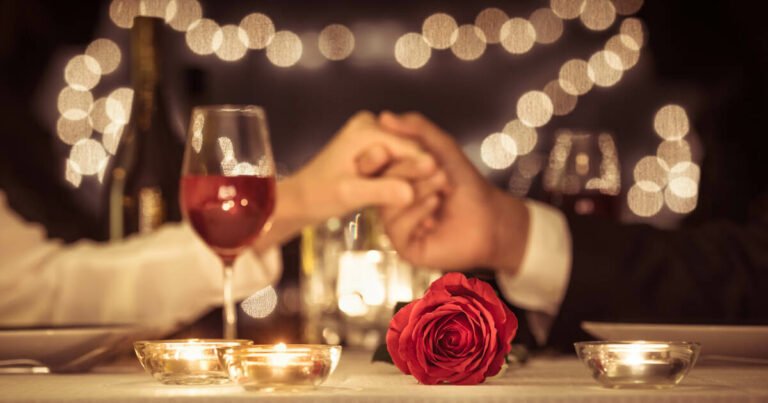 Couple holding hands, savoring a romantic dinner date, celebrating their wedding anniversary.