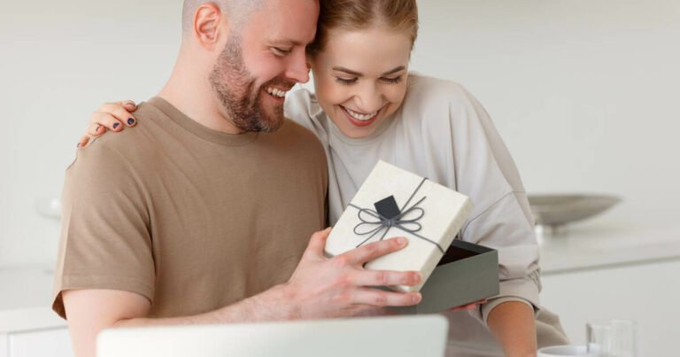 Young couple joyfully opening a gift box together.