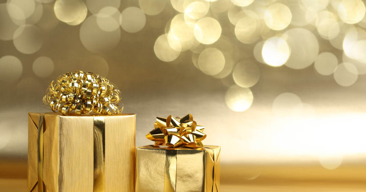 Golden gift boxes gleaming on an abstract background.