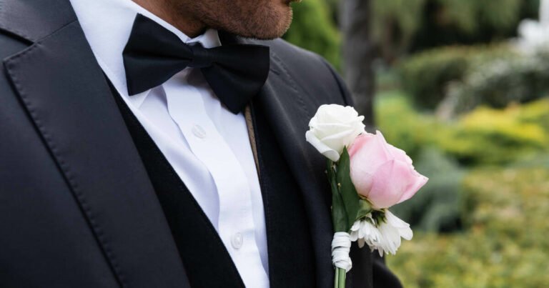 Close up image of a groom on his wedding day, flowers elegantly tucked into his suit.