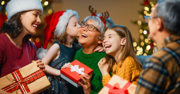 Grandparents, mom, and children exchange gifts and enjoy time together near the tree, creating a loving family atmosphere with presents in the room.