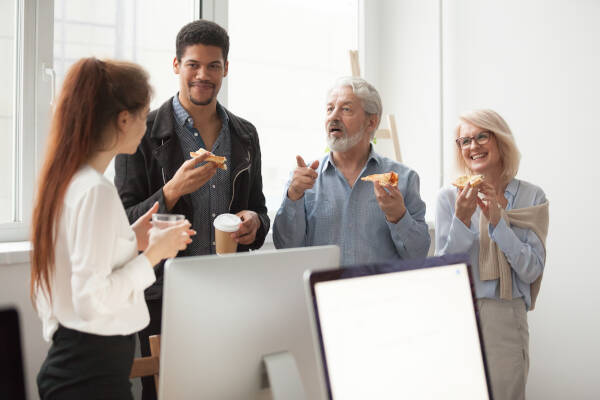 Group of teachers chat, enjoy refreshments, and coffee in the staffroom