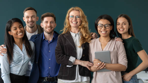 Six teachers smile and pose for a photo in the classroom