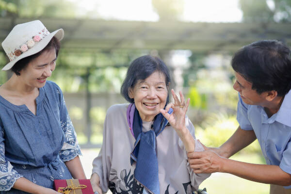 Son and daughter-in-law give a present to an elderly mother