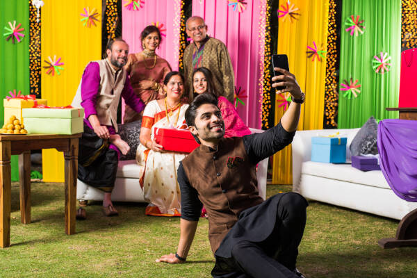 Son taking a selfie picture of the family celebrating the wedding using a smartphone