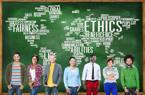 Teachers stand in front of a giant chalkboard with ethics-related words forming the shape of the world behind them