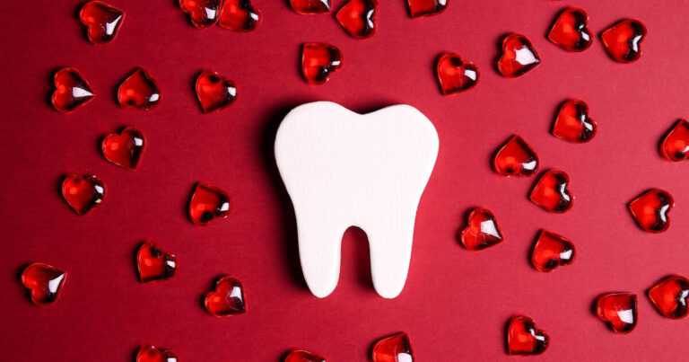 A white tooth on a red background, surrounded by love hearts.