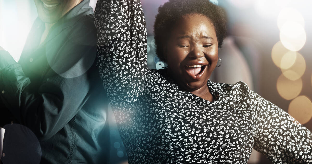 Middle-aged woman dances on the dance floor at a party, smiling and enjoying the moment