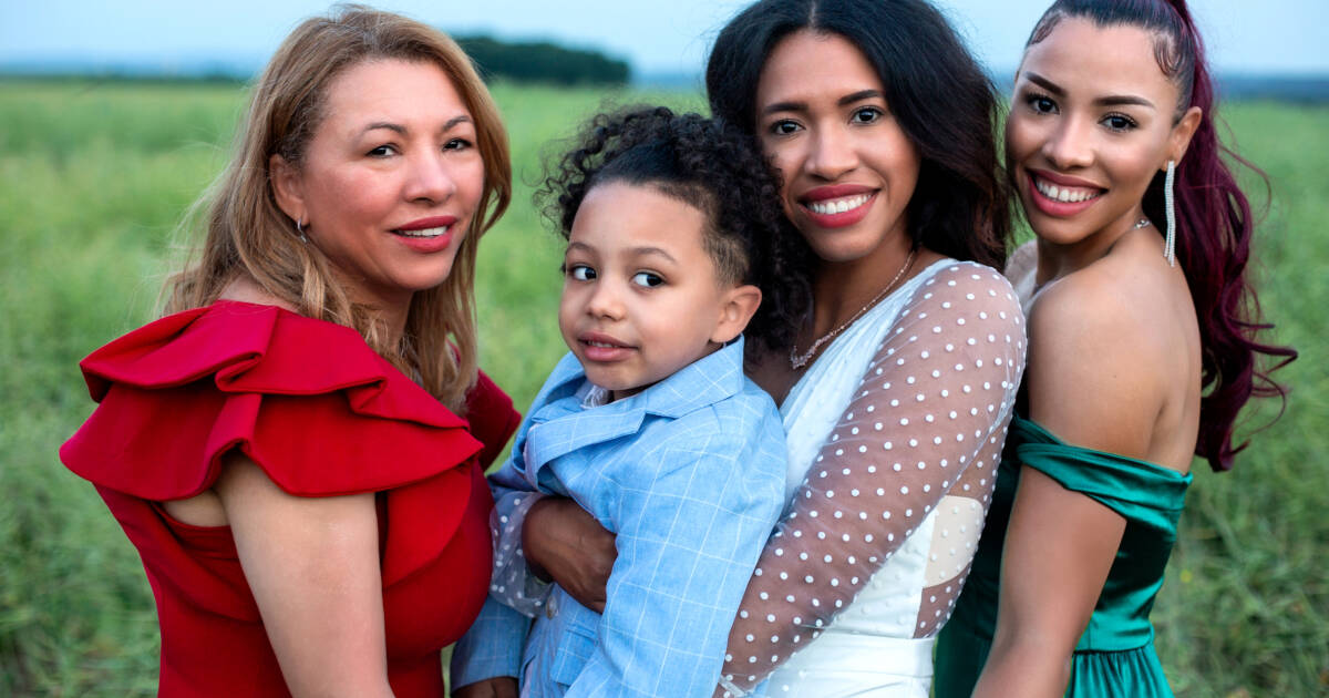 Portrait of the bride-to-be holding her baby, with her mother and sister on either side.