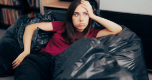 Woman surrounded by plastic bags after decluttering her house