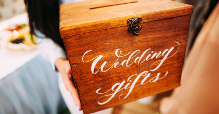 Close up of hands Holding a Wooden Box With A 'wedding gifts' Sign.