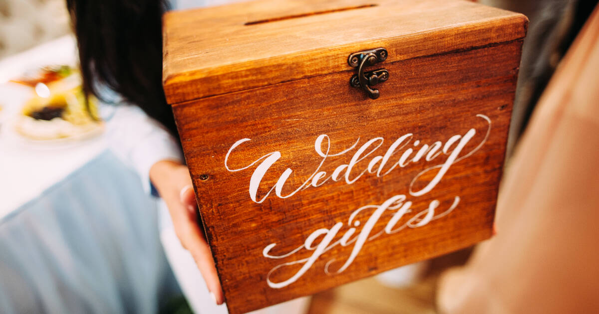 Close up of hands Holding a Wooden Box With A 'wedding gifts' Sign.