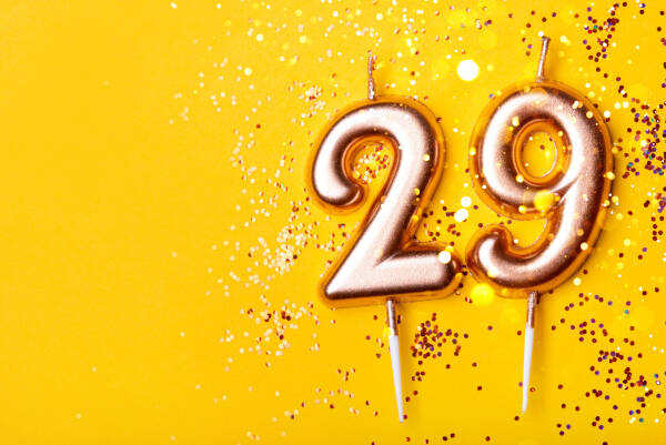 29' candles placed on a yellow background surrounded by confetti.