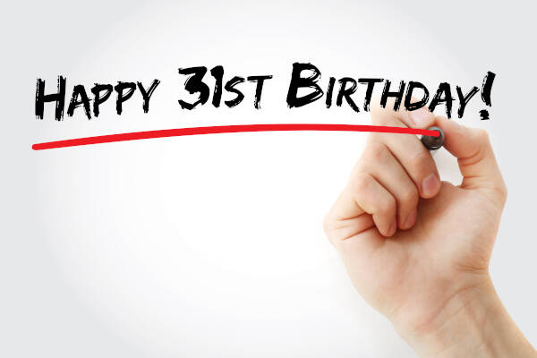 A hand writes 'HAPPY 31ST BIRTHDAY' and underlines it with a red pen against a white background.