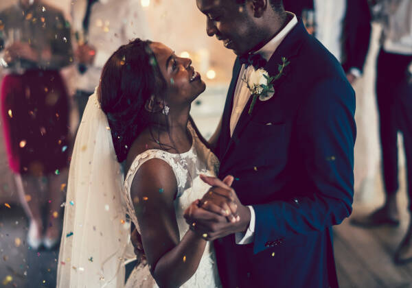 The bride and groom sharing their first dance, both gazing affectionately into each others eyes and holding hands.