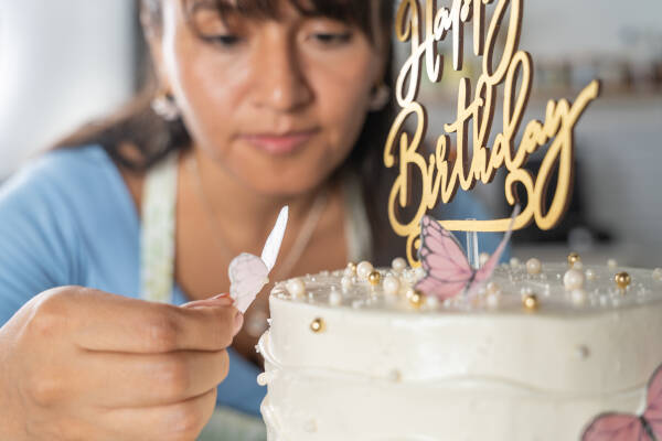 Zoomed-in shot as a baker puts the finishing touches on a stunning birthday cake.