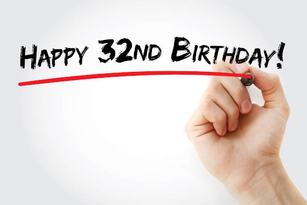 The words 'HAPPY 32ND BIRTHDAY!' written and underlined in red pen by hand against a graywhite background.